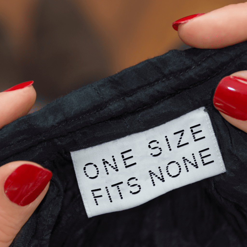 Two hands holding an item of clothing showing the label one size fits none